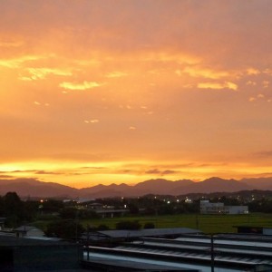 牛舎と夕焼け(豊里　栄子）